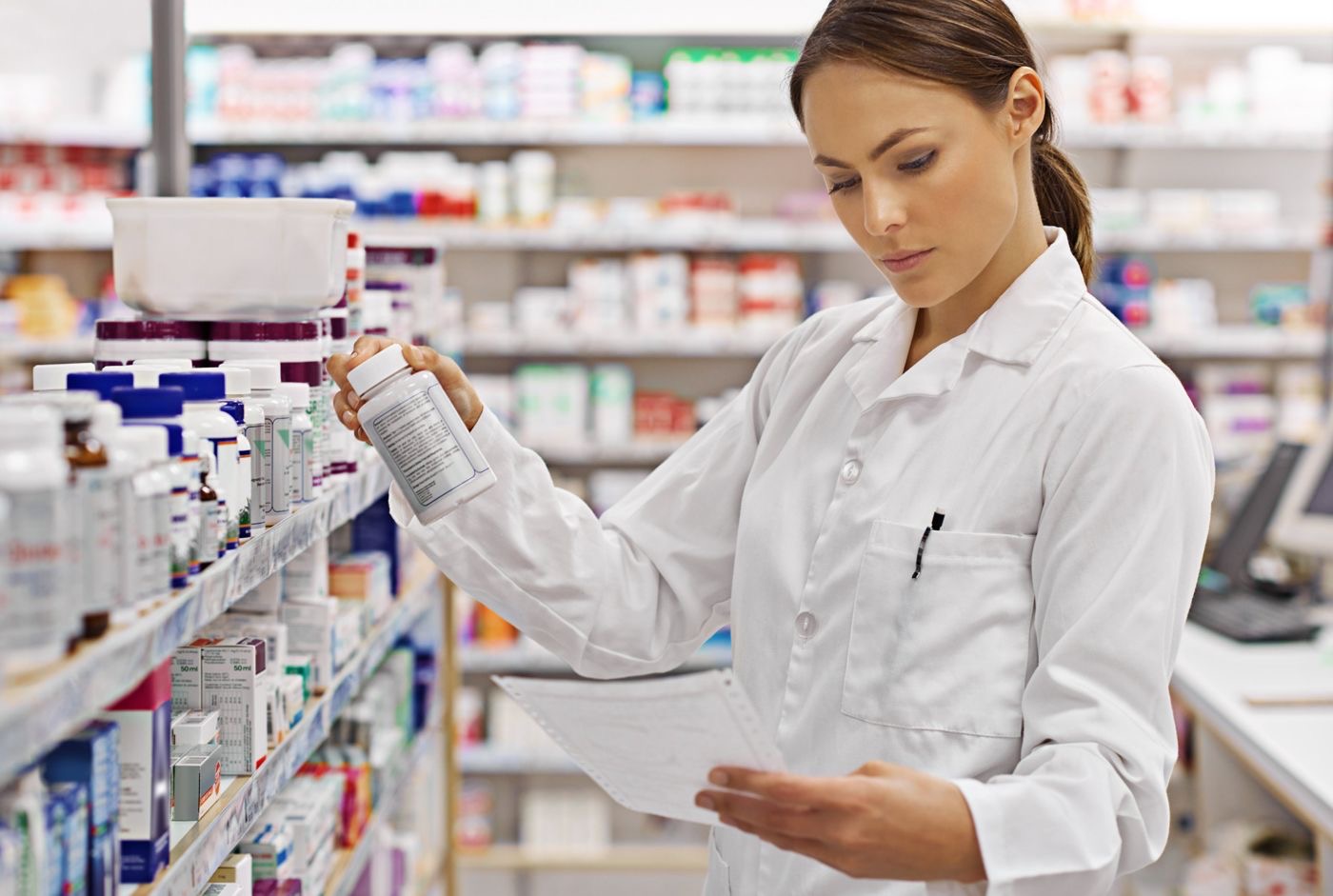 Pharmacist checking a prescription against a medication bottle